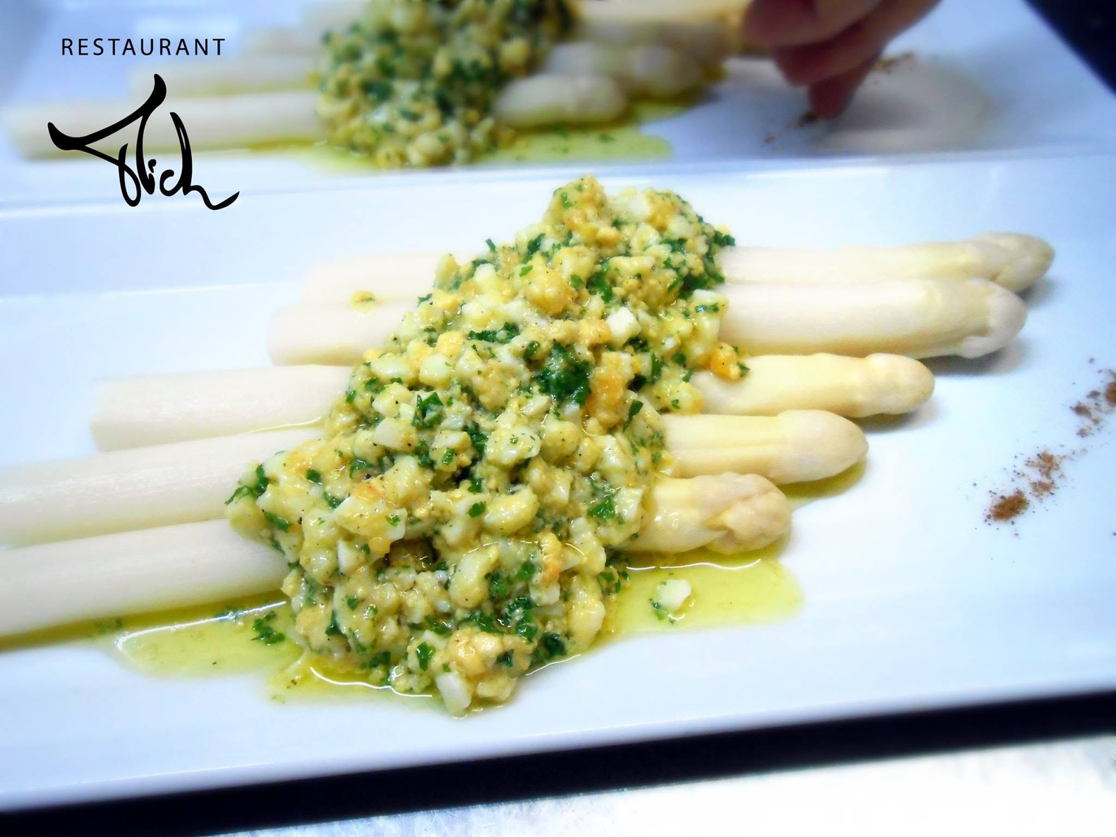 Verzorgd bord met witte asperges, afgewerkt met het Restaurant Mich-logo.